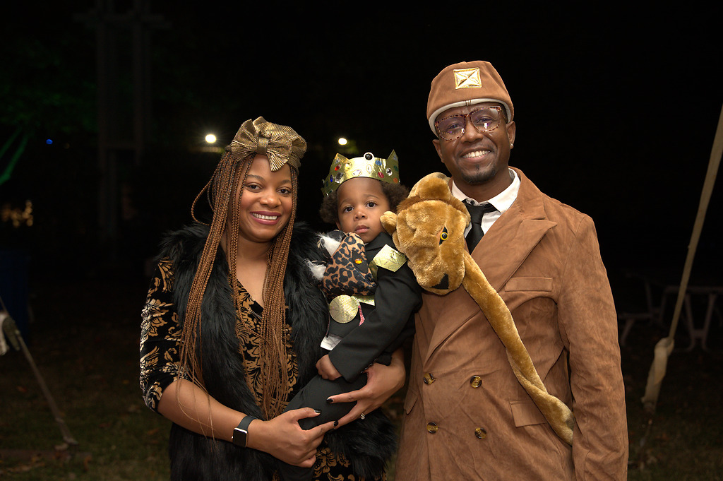 Family members dressed in Halloween costumes from the movie 'Coming to America' smile for the camera.