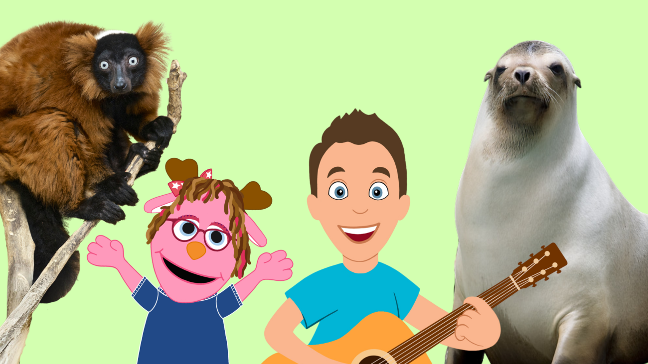 A pink jackalope puppet stands next to a man playing the guitar. On their left is a red ruffed lemur and on their right is a California sea lion.