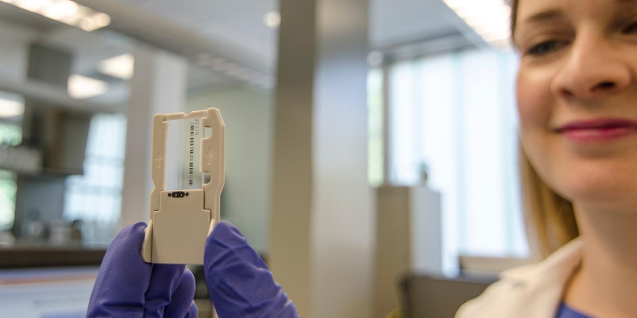 female scientist holding up slide