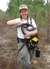 lauren holding an indigo snake in the field