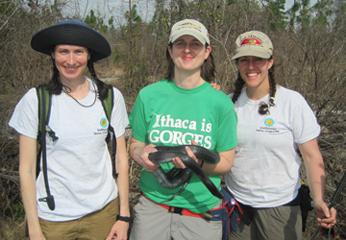 three keepers with middle one holding snake