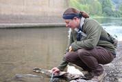 student testing water in stream