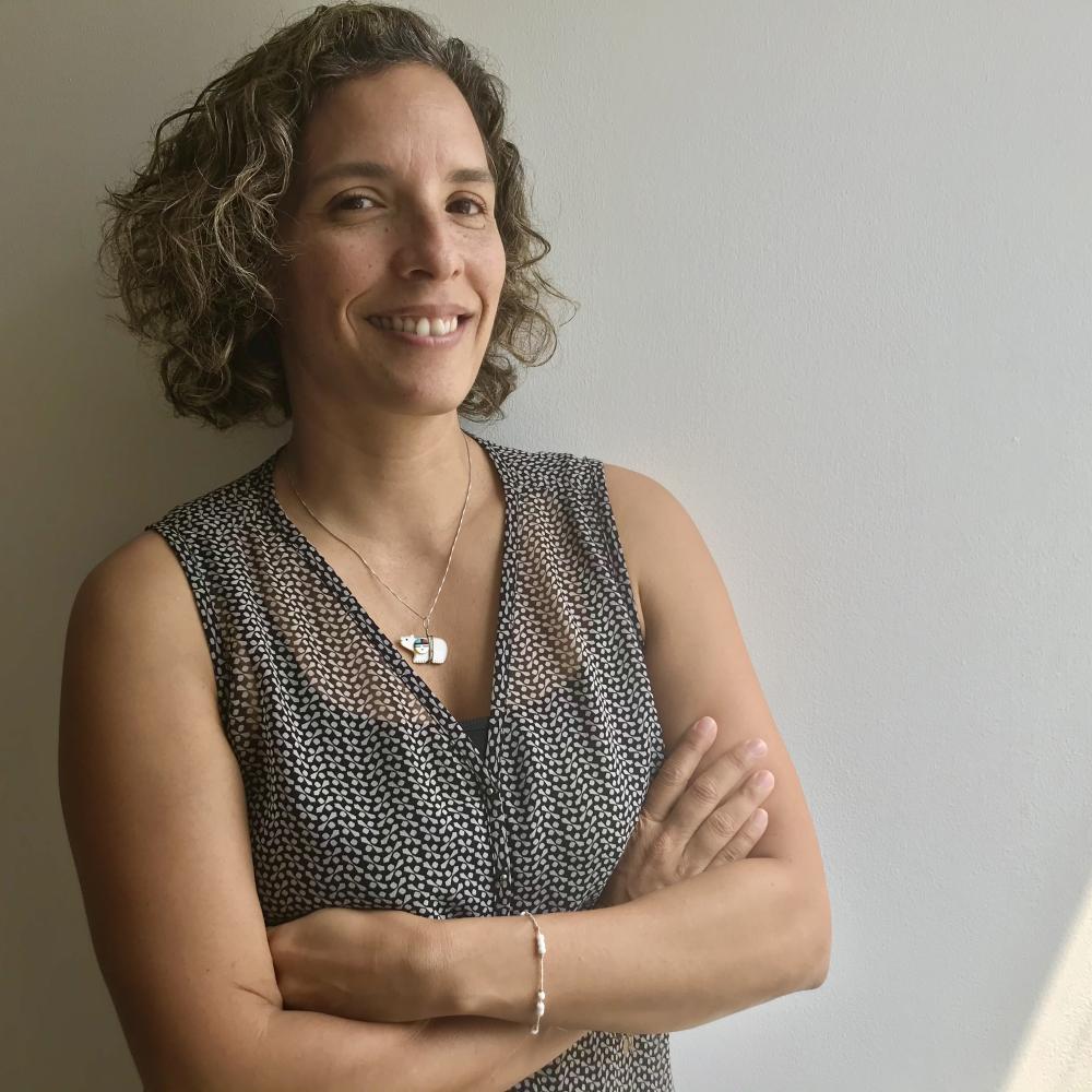 A curly-haired woman smiling at the camera.